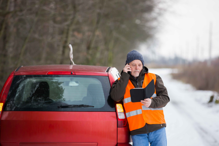 Man standing by car broken down on the road safety