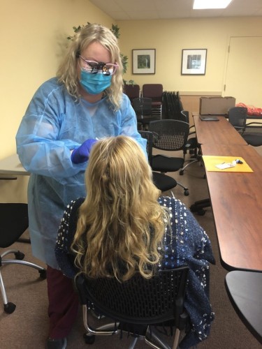 Dental hygienist Rachel Gazeley provides a free dental assessment at a Wellness to Smiles walk-in clinic in Lincoln County, Oregon.