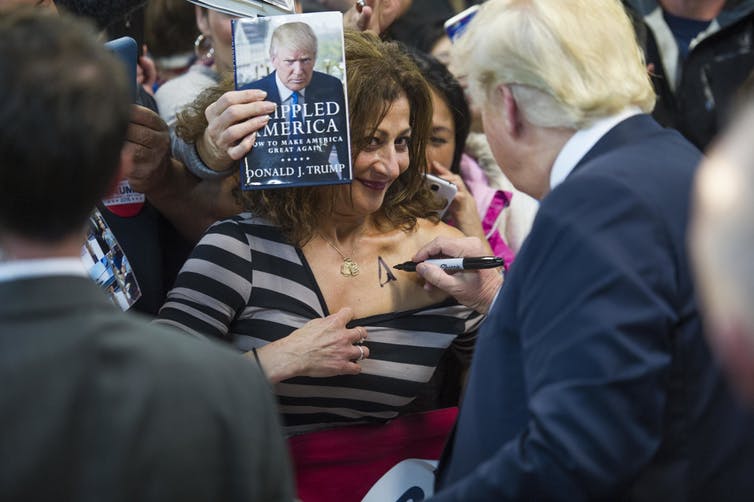 Trump autographing a woman’s chest after a campaign rally in 2015.