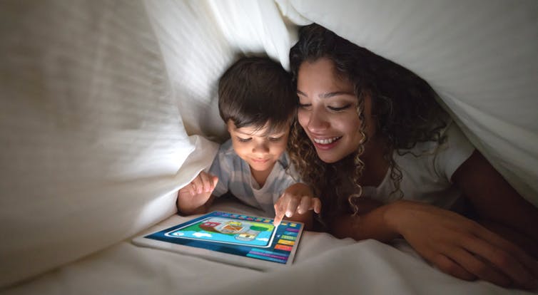 Woman and child read on screen