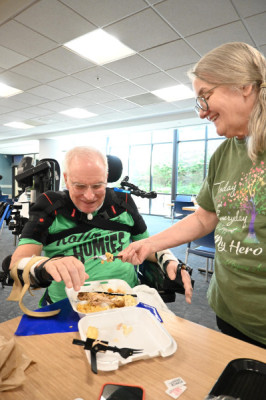 Tom and Norma Elkin laugh as Tom spears a bite of food.