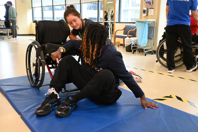 Deontae Davis practices floor transfers with physical therapist Heather Jones.