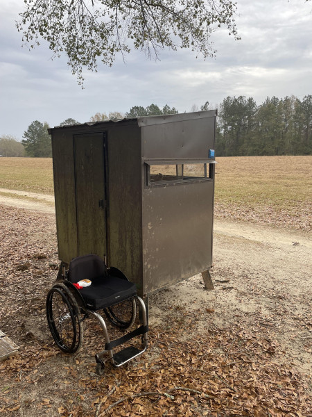 A wheelchair in front of an accessible hunting blind.