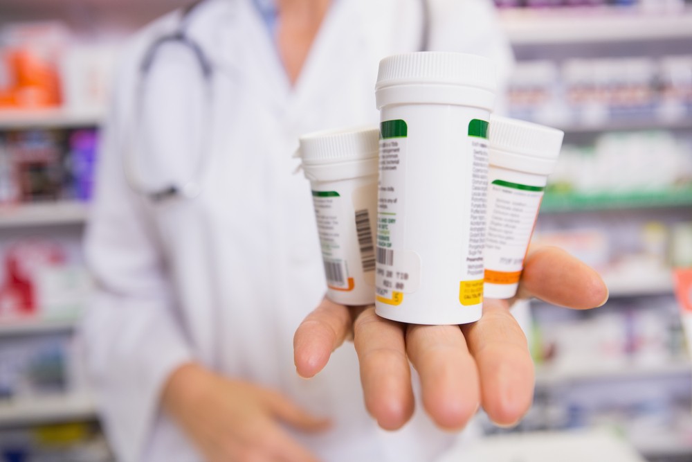 stock-photo-pharmacist-presenting-medications-on-her-hand-in-the-pharmacy-256151683.jpg