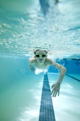 underwater shot of boy swimming laps in pool