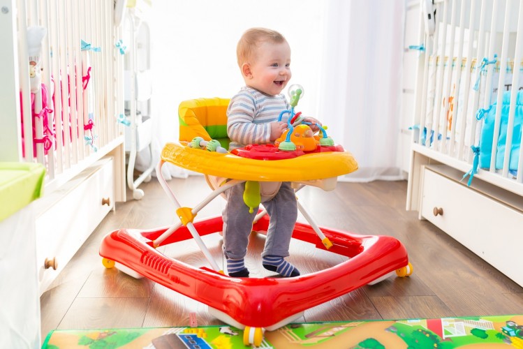 First steps of the boy in a baby walker