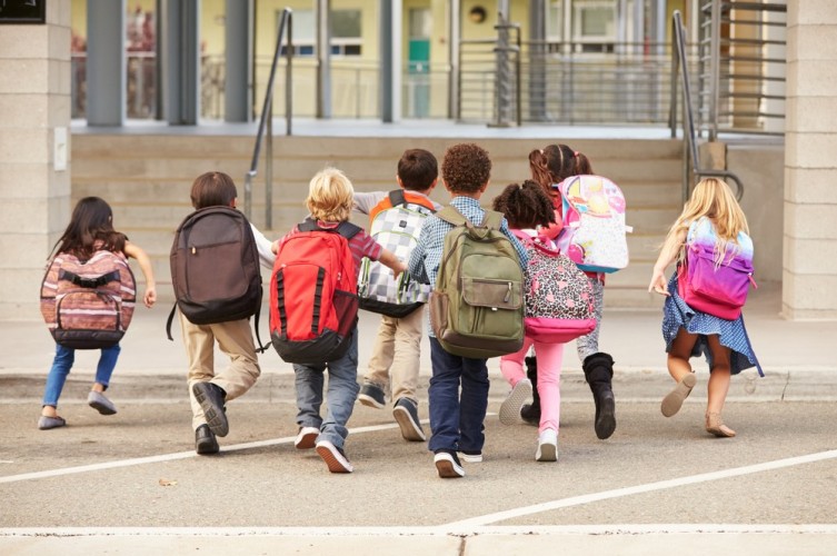 stock-photo-elementary-school-kids-running-into-school-back-view-388630567.jpg