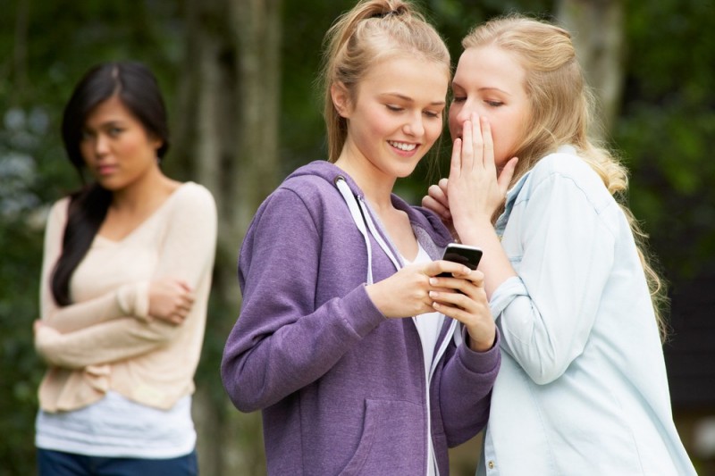stock-photo-teenage-girl-being-bullied-by-text-message-on-mobile-phone-151845986.jpg
