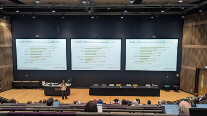 A presenter at the UKRN conference speaking to the audience with slides