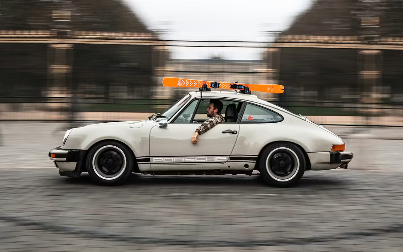 Man_driving_a_classic_Porsche_911_in_Paris__set_of_skis_on_the_roof