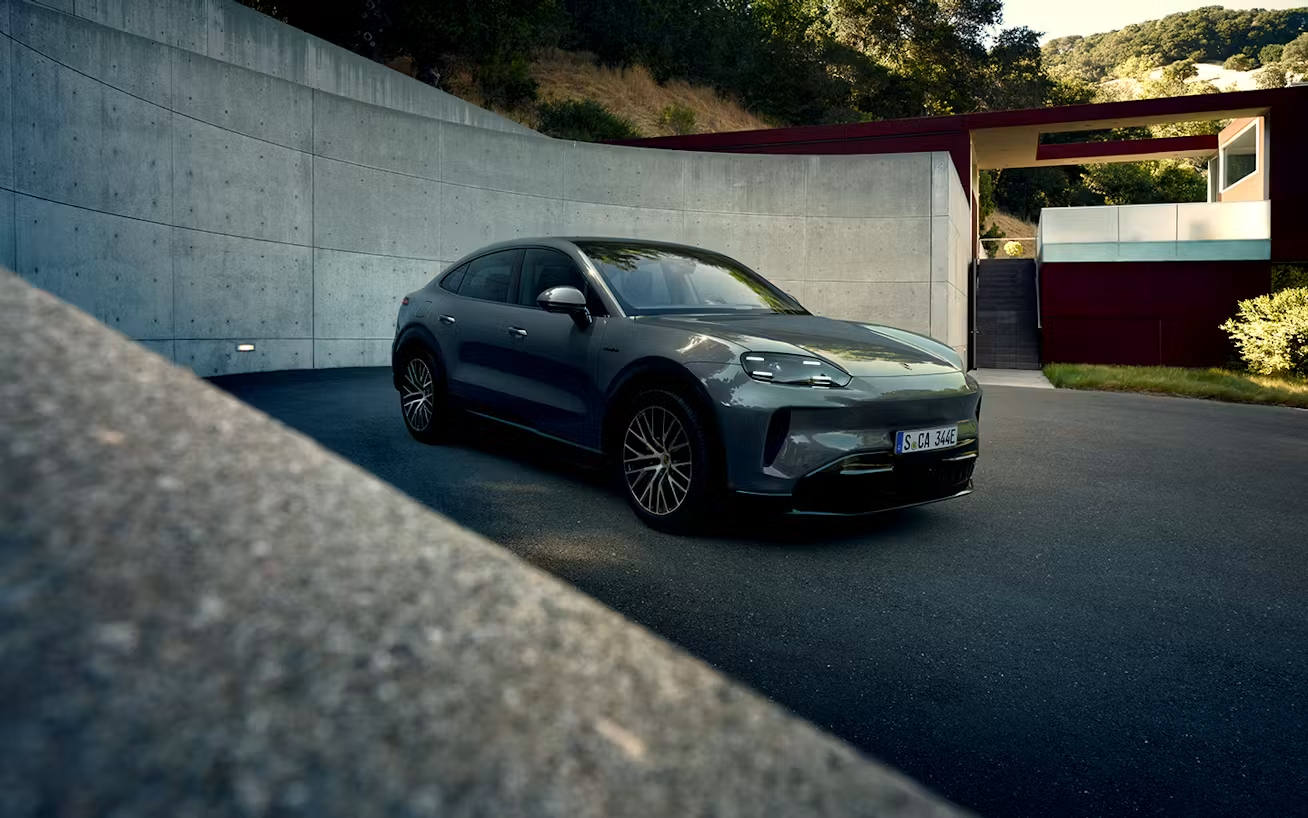 Front_three-quarter_view_of_Cayenne_CoupeÌ__Electric_parked_in_front_of_modern_home