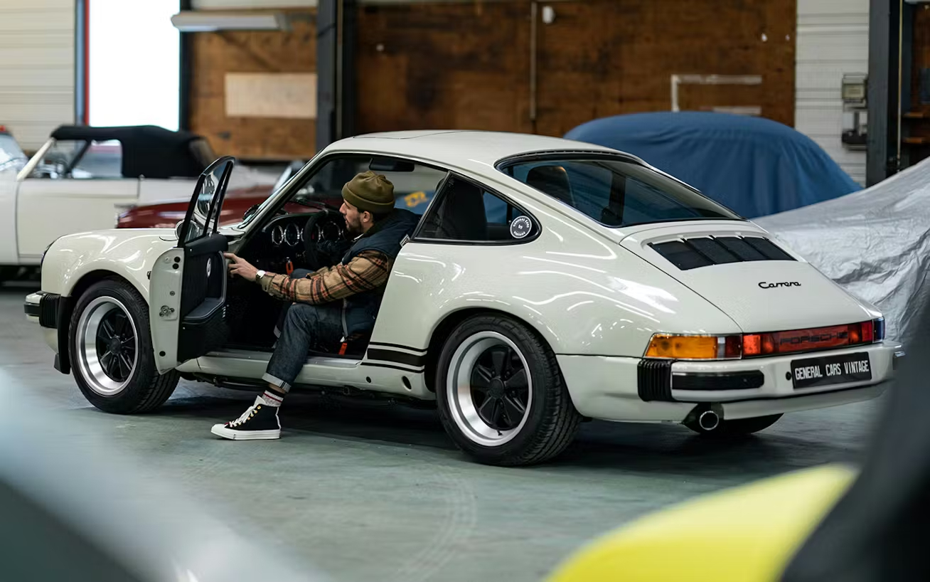Man_exits_restored_classic_Porsche_911_in_cream_colour