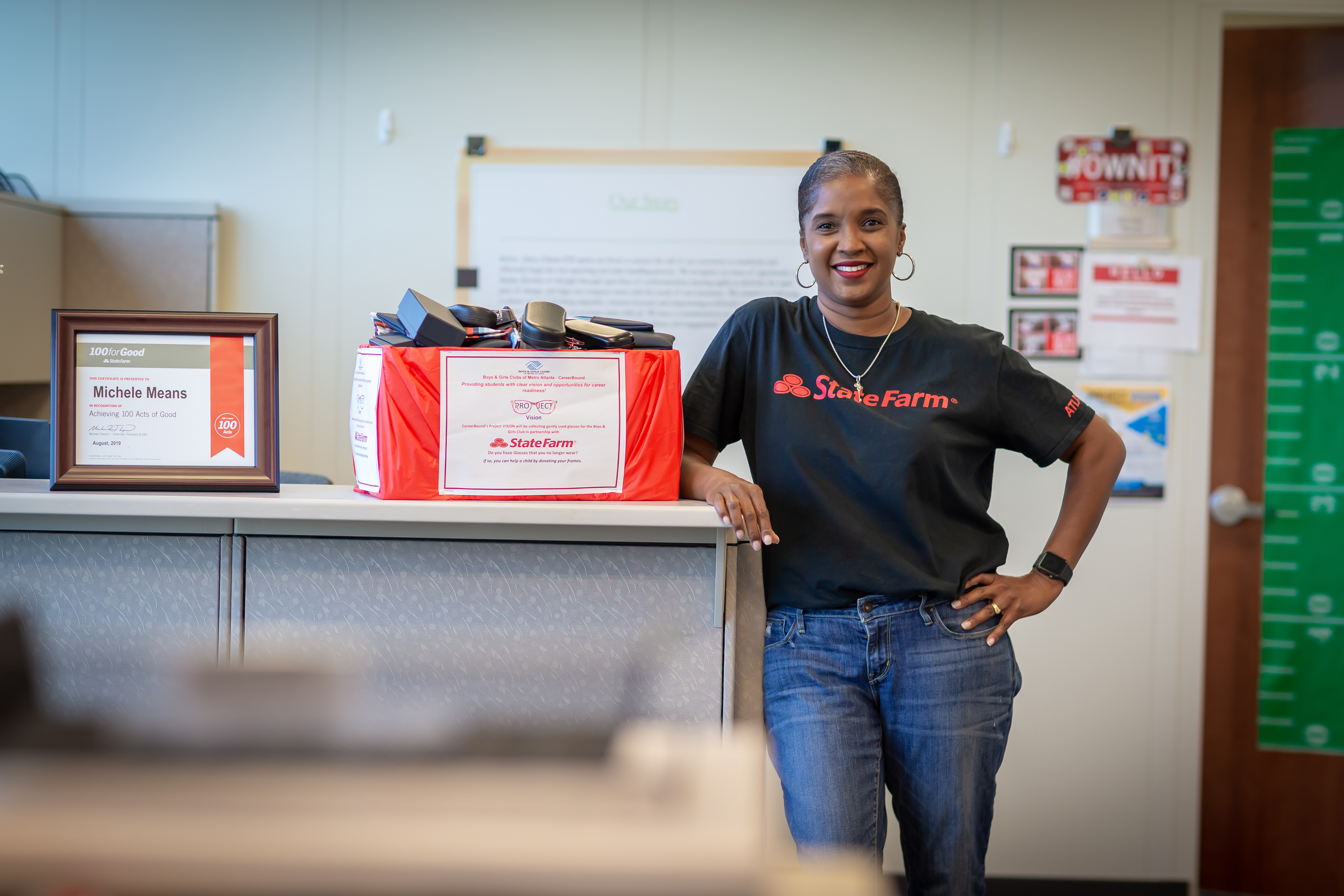 State Farm employee Michelle Means with some of the eyeglass frames collected as part of her anniversary project to give back. The frames were donated to the Boys and Girls Club of Metro Atlanta to help meet the vision needs of the Club's members.