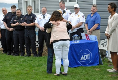 Women hugging with firemen in the background