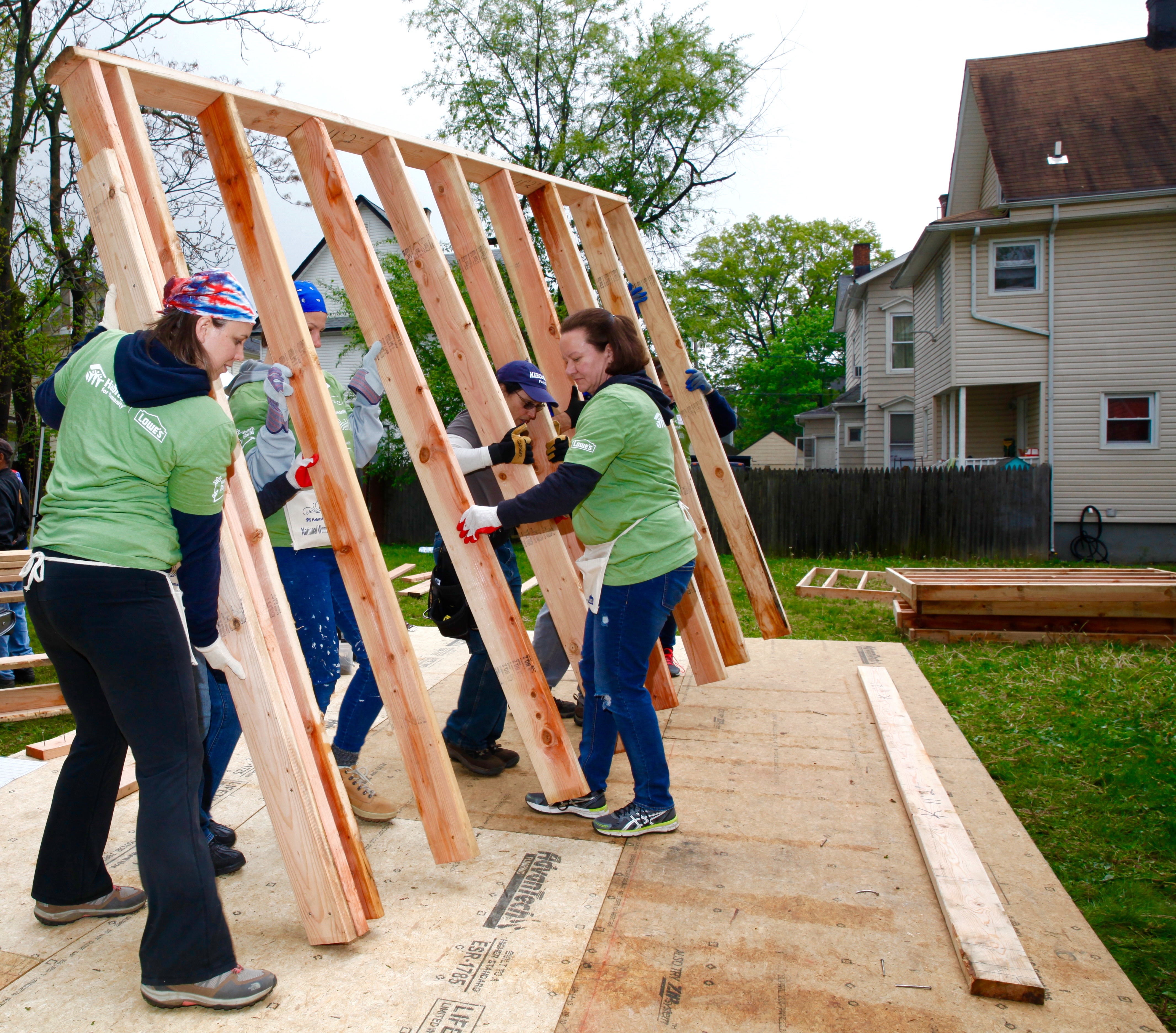 Habitat for Humanity members putting up a frame of a future house.