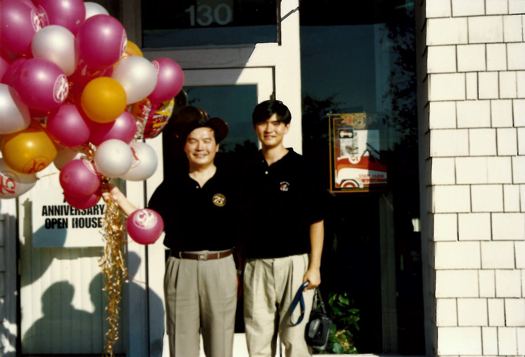 Johnatheme and Steven stand outside the agency with balloons