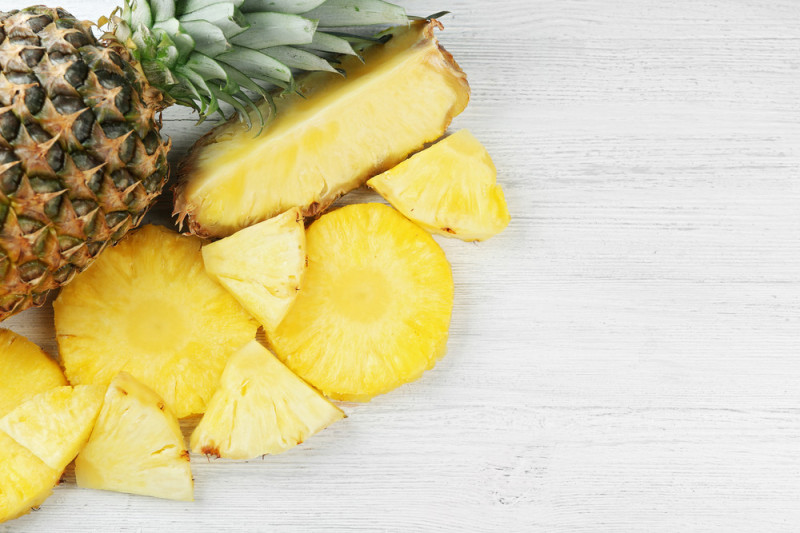 Cut fresh pineapple on wooden background stock photo-399593335.jpg