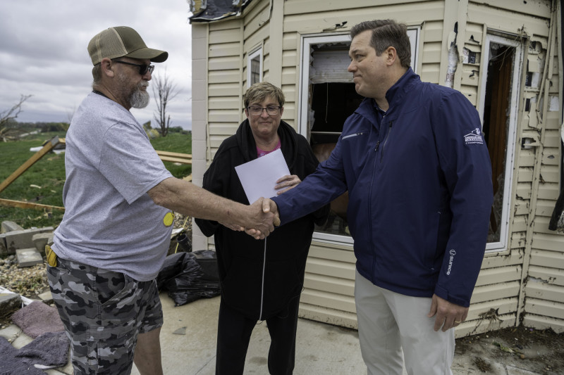 American Family Chair and CEO Bill Westrate brings a check to customers Doug and Greta Schlabs, whose home was destroyed by a tornado.