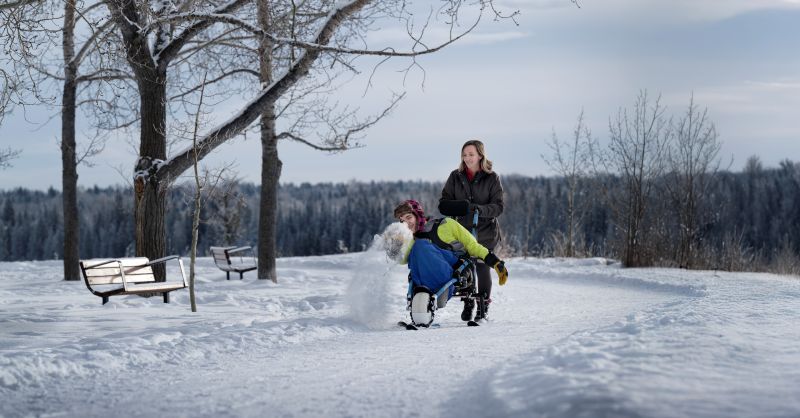 Kanen and his mom Candice McLellan explore North Glenmore Park using an All-Terrain Wheelchair (ATW) with skis borrowed from The City of Calgary as part of a new pilot project. 