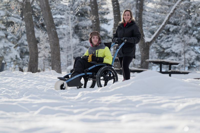 Kanen and his mom Candice McLellan take an All-Terrain Wheelchair (ATW) with wheels for a spin through North Glenmore Park.