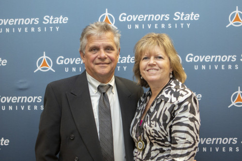 A man and woman smiling in front of GovState backdrop