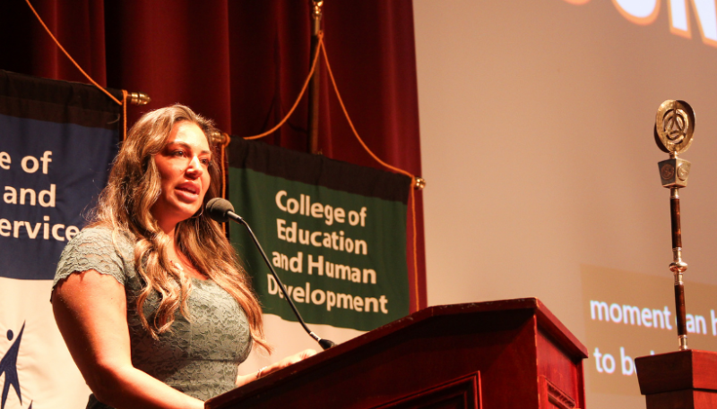 Governors State University Alumna Martina Matthews speaking on stage at a podium