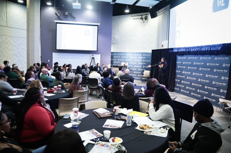 A young black man delivering a keynote address to Governors State University leaders