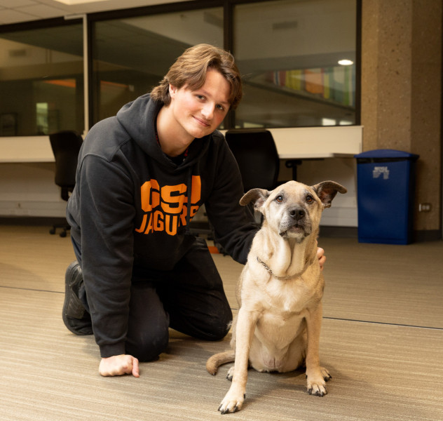 A Governors State University student with Sandy the Therapy Dog