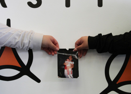 Picture of two women's hands holding up a childhood photo together