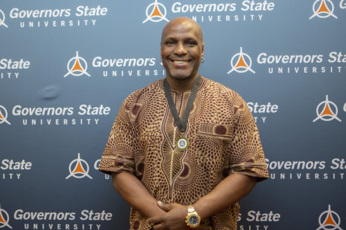A man smiling in front of GovState backdrop