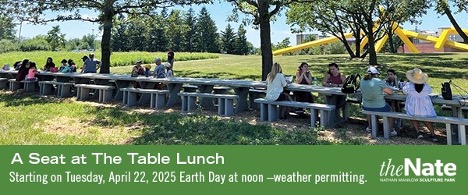People sitting outside at a 100-ft long stone table on Governors State University campus