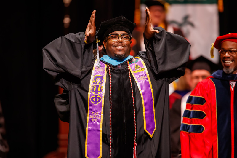 Mike Davis in doctoral regalia at Governors State University Doctoral Hooding Ceremony