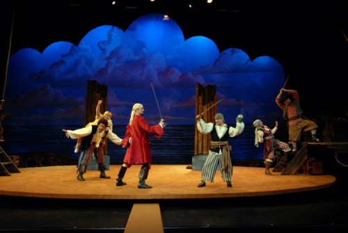 Pirates have a sword fight on the deck of a ship at dusk