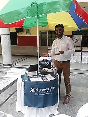 Krishna Prasanth standing at a GSU recruiting booth in India 