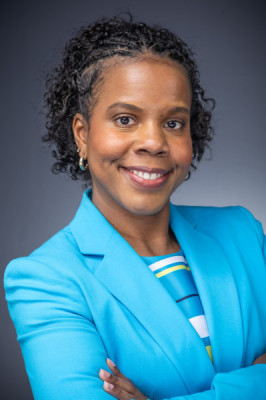 Professional headshot of a smiling woman in a bright blue blazer