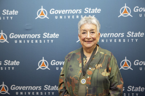 An older lady smiling in front of GovState backdrop