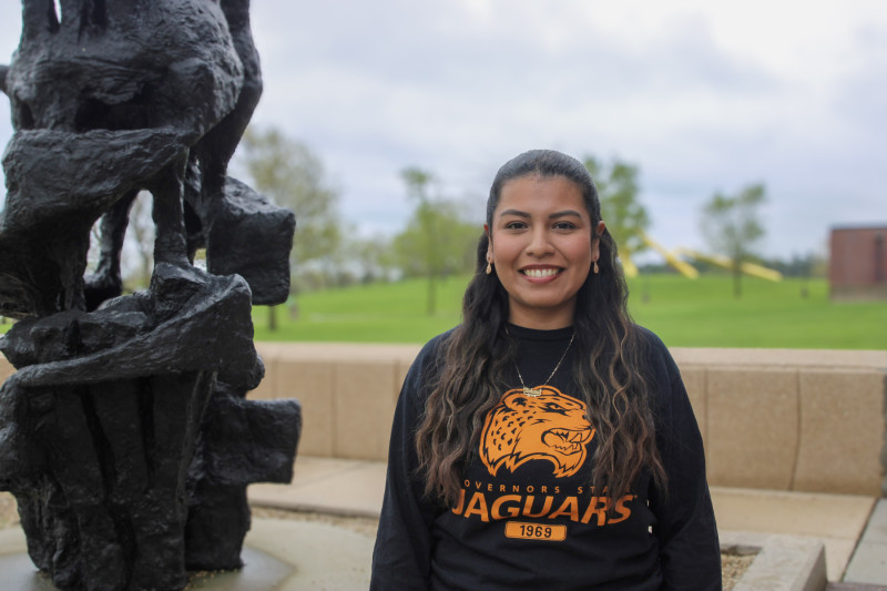 Portrait photo of a Governors State University student near a campus sculpture