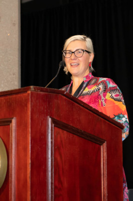 A woman speaking at a podium for Distinguished Alumni Reception 2024