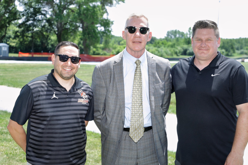 Three men standing side by side in business casual clothes