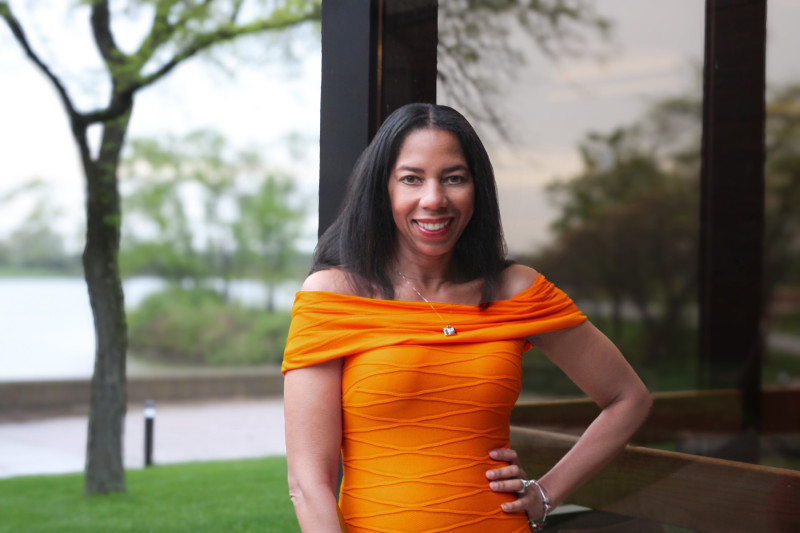 Portrait photo of a smiling woman wearing an orange dress