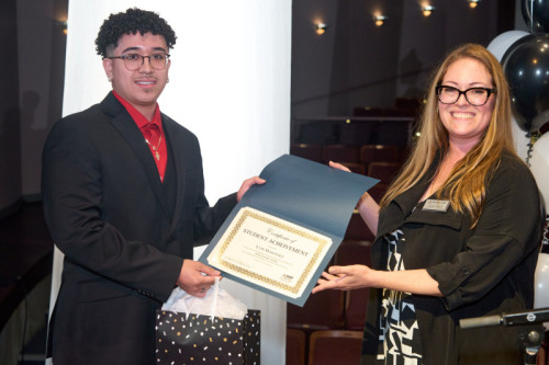 A Governors State University student receiving a certificate from Dual Degree Program Director