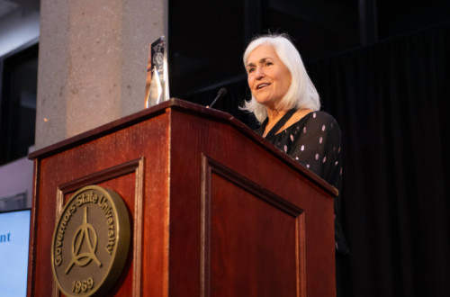 A woman speaking at a podium for Distinguished Alumni Reception 2024