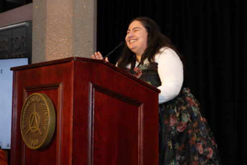A woman speaking at a podium for Distinguished Alumni Reception 2024