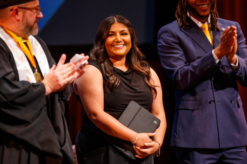Governors State University alumna Kaylie Dahms smiling on stage at Convocation 2025