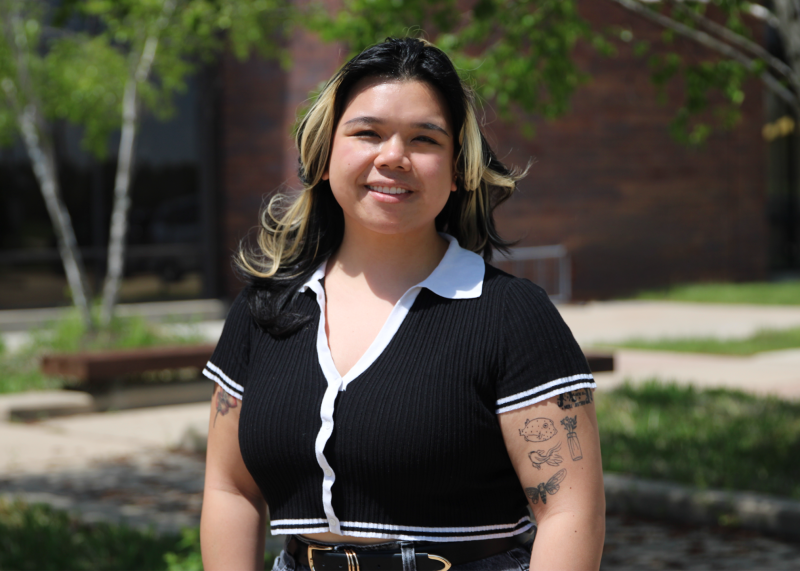 A smiling woman standing on an outdoor patio
