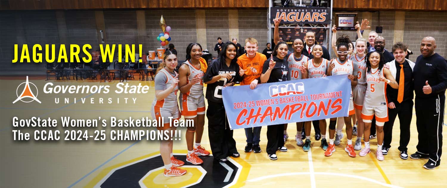 Governors State University women's basketball team and coaches taking a photo on home court to celebrate their 2025 championship win