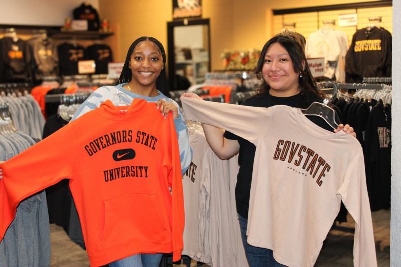 Two Governors State University students holding GovState shirts