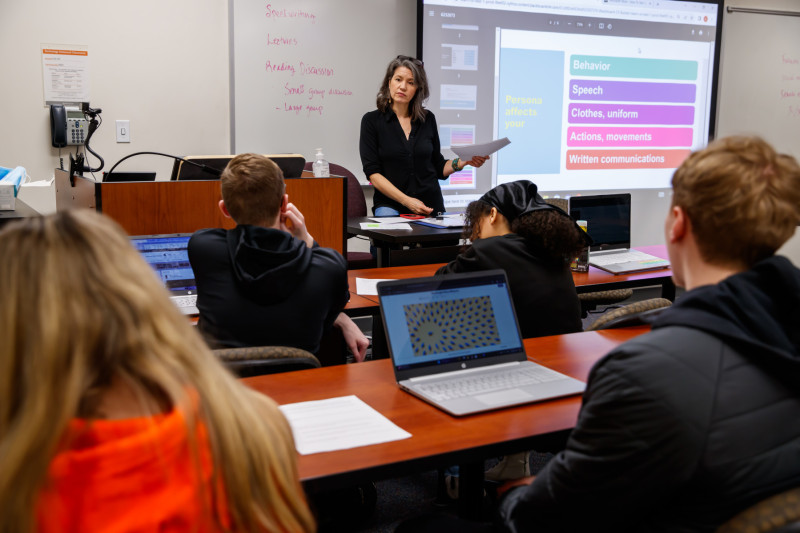 A professor at a podium giving a presentation to a college class