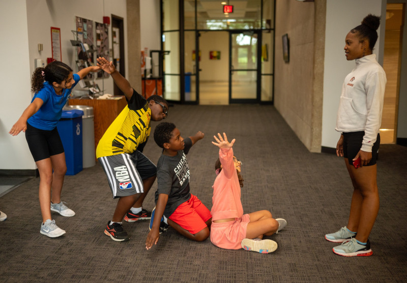 Students aged 11-16 participating in STEAM Camp activity near Governors State University visual arts gallery