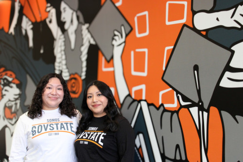Two smiling sisters wearing Governors State University long sleeve shirts